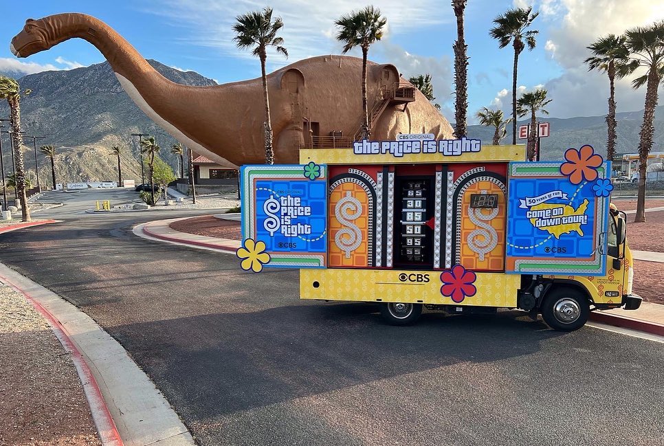 Price is Right glass truck in front of a dinosaur sculpture